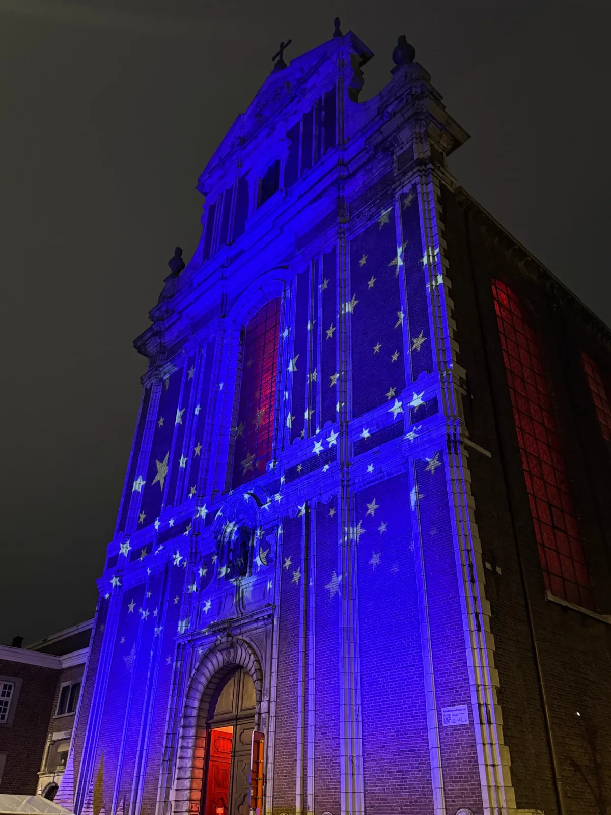 Gevel van de Minderbroederskerk in Sint-Truiden in blauw licht met geprojecteerde sterren
