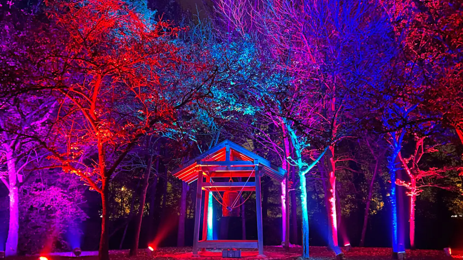 Klokkenpaviljoen in de Japanse Tuin van Hasselt, vanonder aangelicht in rood en blauw tijdens Luminate Lichtfestival