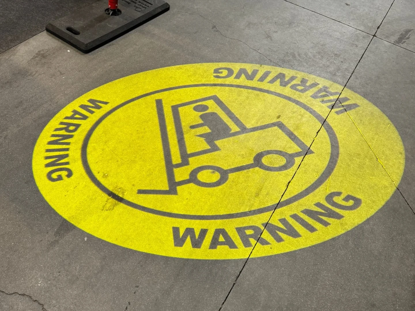 Geprojecteerd WARNING-pictogram met heftruck op een magazijnvloer