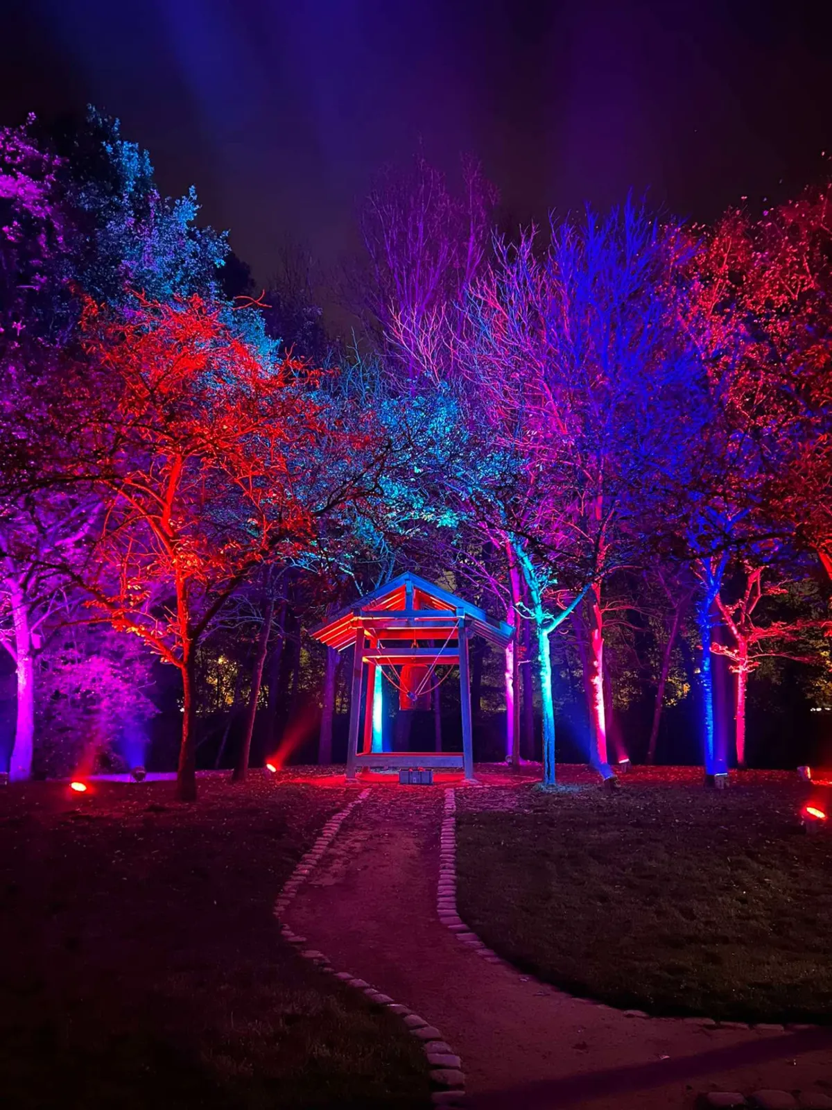 Klokkenpaviljoen in de Japanse Tuin omringd door rood, blauw en paars uitgelichte bomen